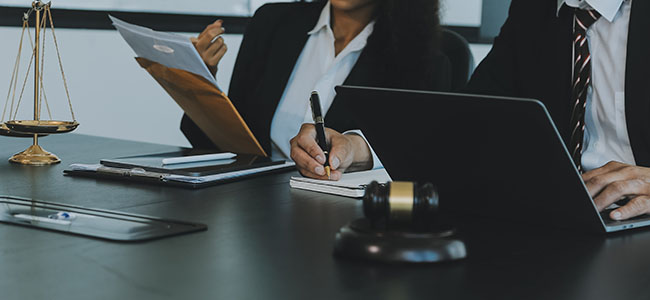 When to Lawyer Up judge gavel with justice lawyers having team meeting at law firm