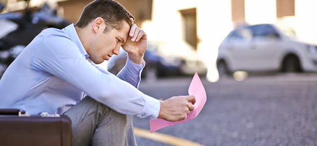 i never thought this would happen to me. a businessman holding a pink slip terminating his employment.